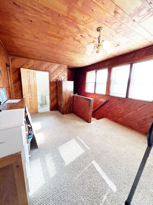 interior space with carpet flooring, wooden ceiling, wooden walls, and vaulted ceiling