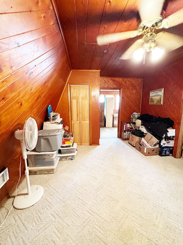 additional living space featuring ceiling fan, lofted ceiling, wooden walls, carpet, and wood ceiling