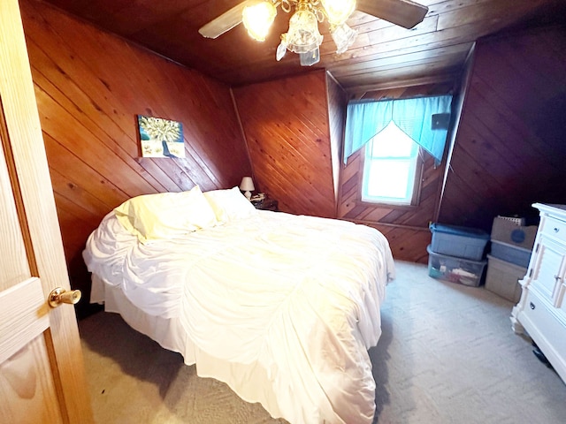 carpeted bedroom with wood ceiling, ceiling fan, and wood walls