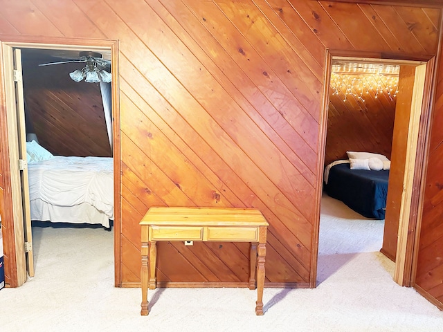 hall featuring carpet flooring and wood walls