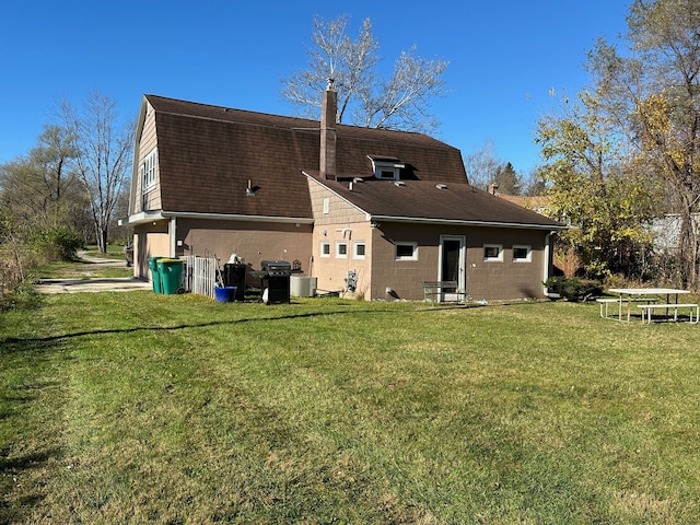 rear view of property featuring a yard, central AC, and a garage