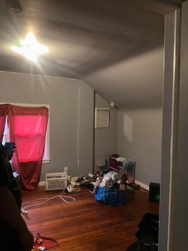 additional living space with a wall mounted AC, wood-type flooring, and lofted ceiling