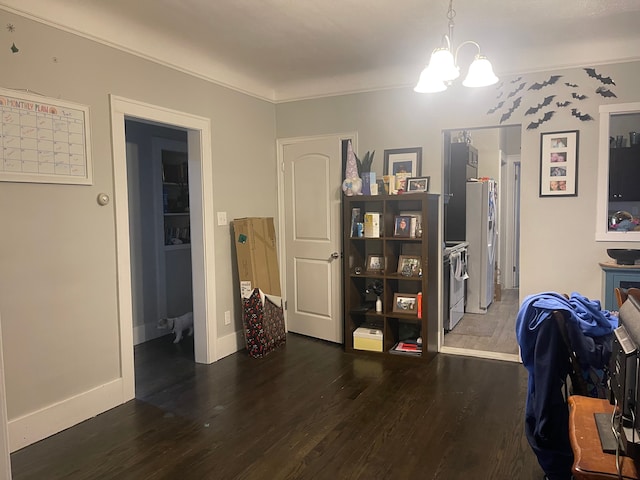 home office with dark wood-type flooring, a notable chandelier, and ornamental molding