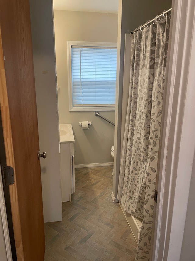 bathroom featuring a shower with curtain, vanity, toilet, and parquet flooring