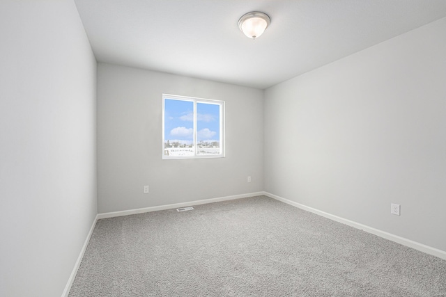 unfurnished room with carpet flooring, visible vents, and baseboards