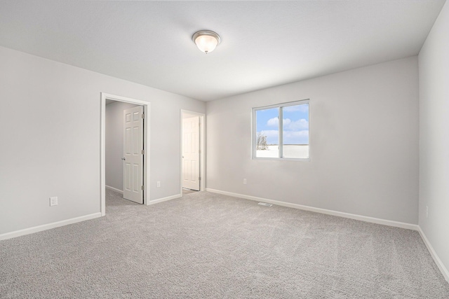 carpeted spare room featuring baseboards