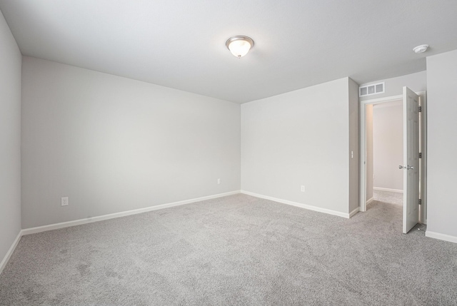 carpeted empty room featuring visible vents and baseboards