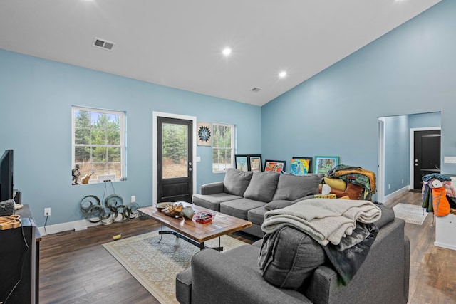 living room with dark hardwood / wood-style flooring and high vaulted ceiling