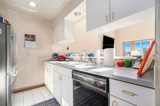 kitchen with stainless steel fridge, sink, dishwasher, white cabinetry, and light tile patterned flooring
