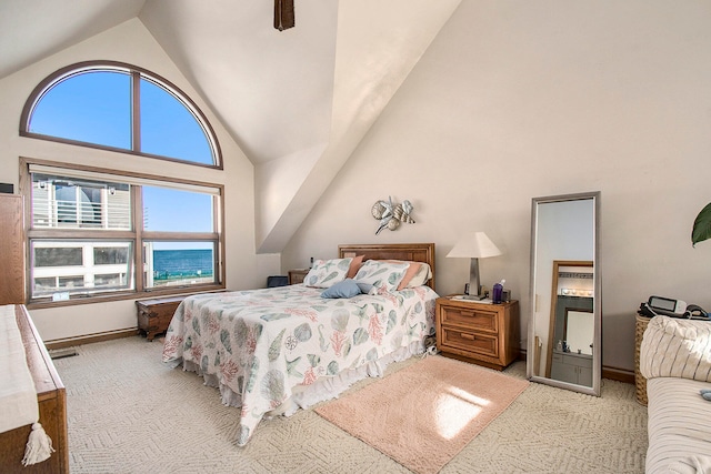 bedroom featuring light colored carpet, high vaulted ceiling, and multiple windows