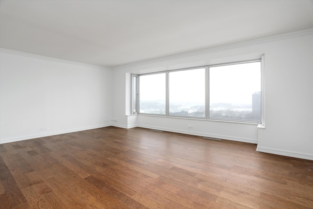 empty room with wood-type flooring and ornamental molding