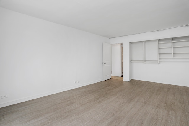 unfurnished bedroom featuring hardwood / wood-style floors and a closet