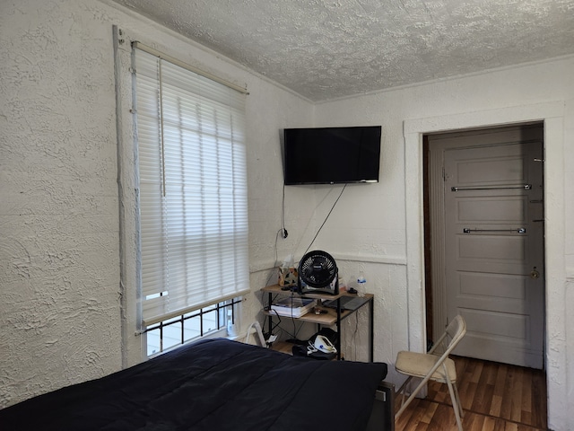 bedroom with dark hardwood / wood-style floors and a textured ceiling