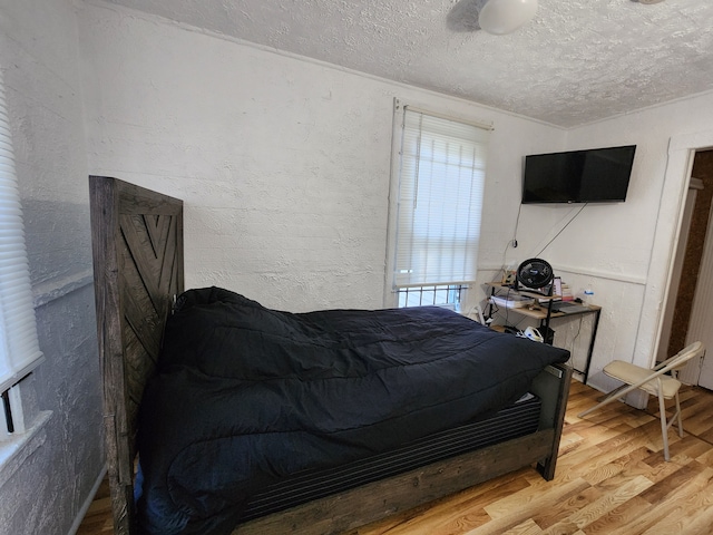 bedroom featuring hardwood / wood-style flooring and a textured ceiling