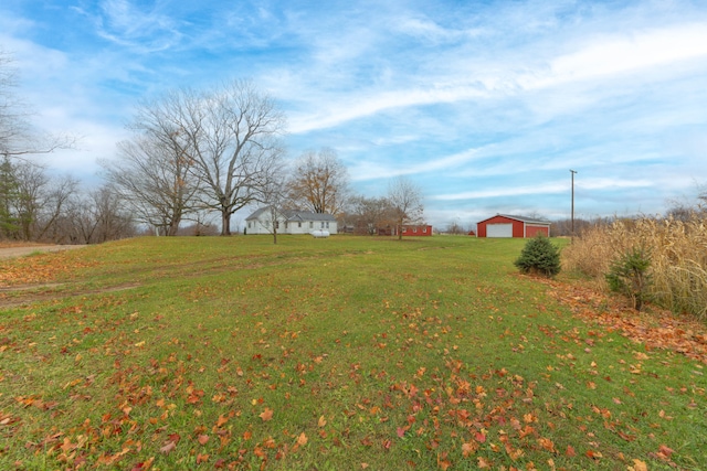 view of yard with an outbuilding, a rural view, and a garage