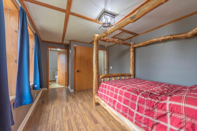 unfurnished bedroom with wood-type flooring, ensuite bath, and crown molding