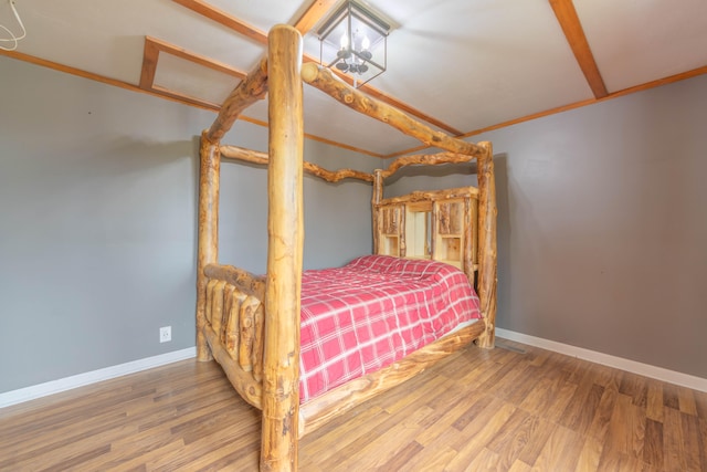 bedroom with hardwood / wood-style floors and ornamental molding