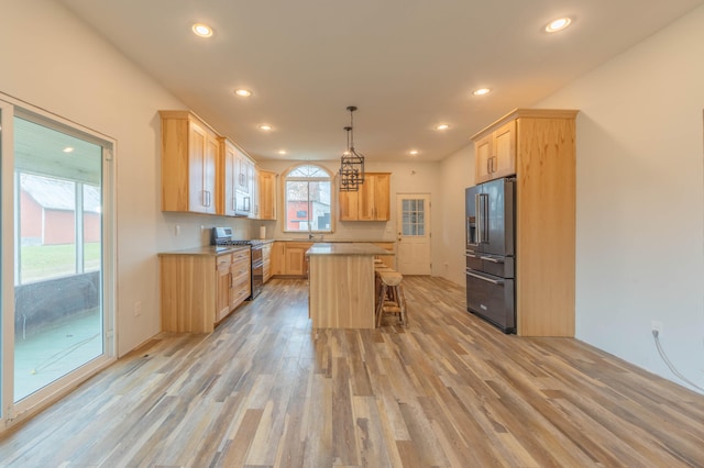 kitchen featuring a wealth of natural light, appliances with stainless steel finishes, a kitchen island, and hanging light fixtures