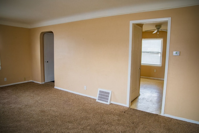 empty room featuring ornamental molding, light colored carpet, and ceiling fan