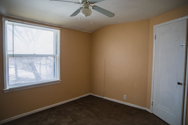 carpeted spare room with ceiling fan and vaulted ceiling