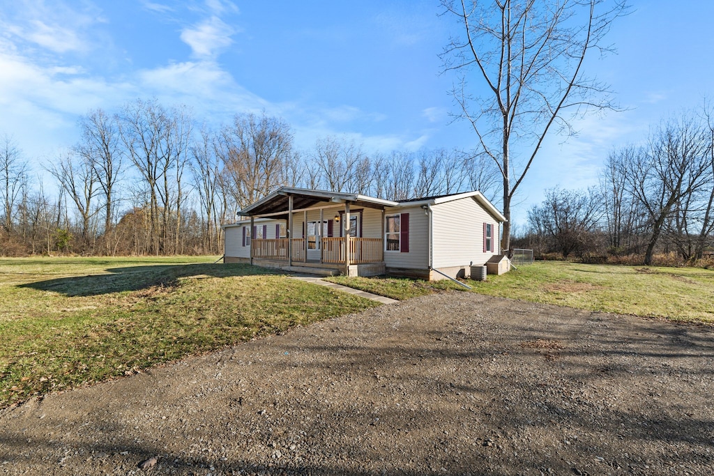 manufactured / mobile home with covered porch and a front lawn