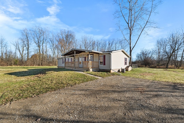 manufactured / mobile home with covered porch and a front lawn