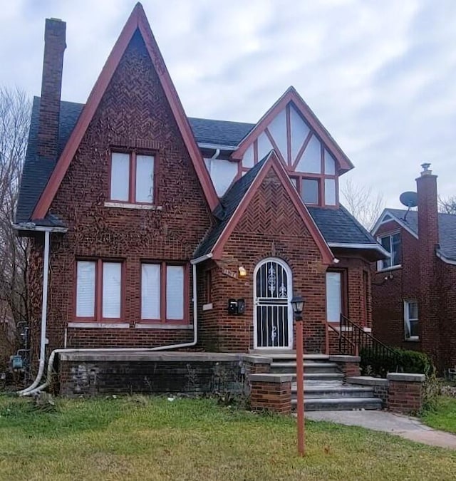 english style home featuring a front lawn