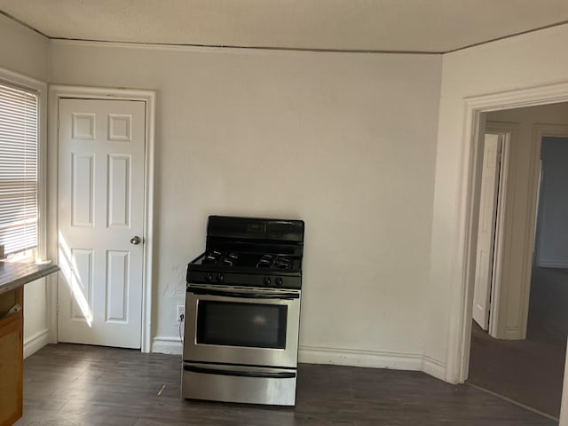 kitchen with dark hardwood / wood-style flooring, a healthy amount of sunlight, and stainless steel range with gas stovetop