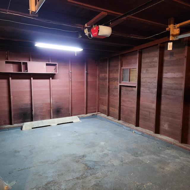 garage featuring wood walls and a garage door opener