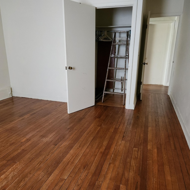 unfurnished bedroom featuring dark hardwood / wood-style floors and a closet