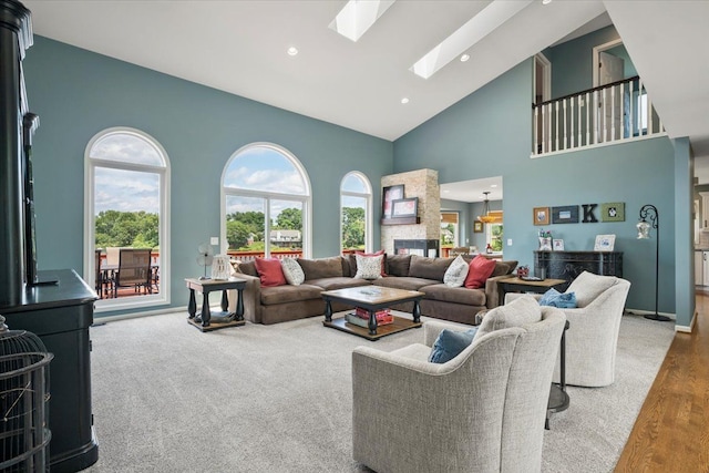 living room featuring hardwood / wood-style flooring, high vaulted ceiling, a wealth of natural light, and a skylight