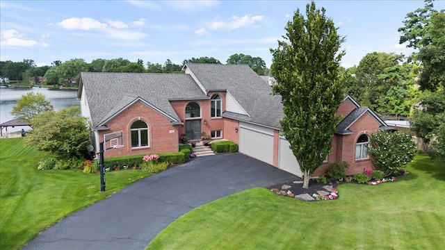 view of front of property with a water view, a front yard, and a garage