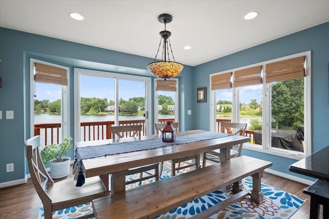 dining space with a water view and dark wood-type flooring