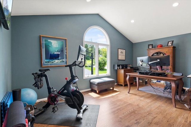 exercise area featuring light hardwood / wood-style floors and lofted ceiling