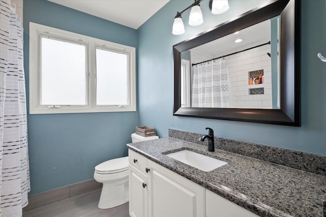 bathroom featuring vanity, toilet, wood-type flooring, and a wealth of natural light