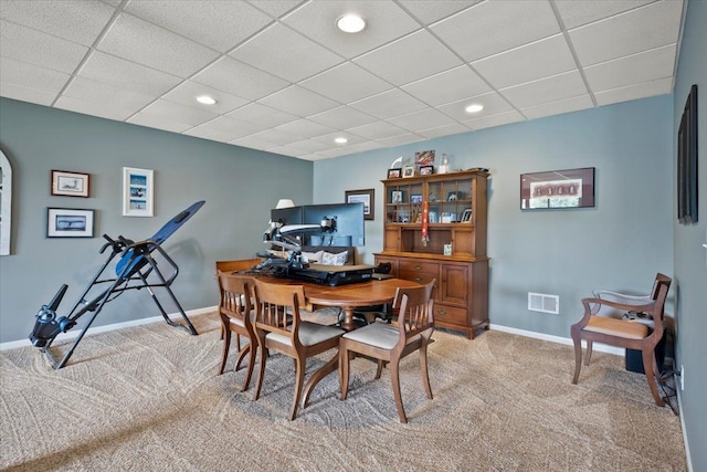 carpeted dining room featuring a drop ceiling