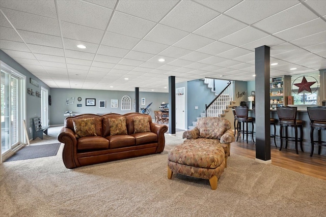 living room with a paneled ceiling and hardwood / wood-style flooring