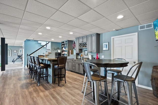 dining space with a paneled ceiling and light hardwood / wood-style flooring