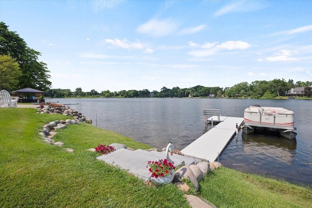 dock area with a gazebo, a water view, and a lawn