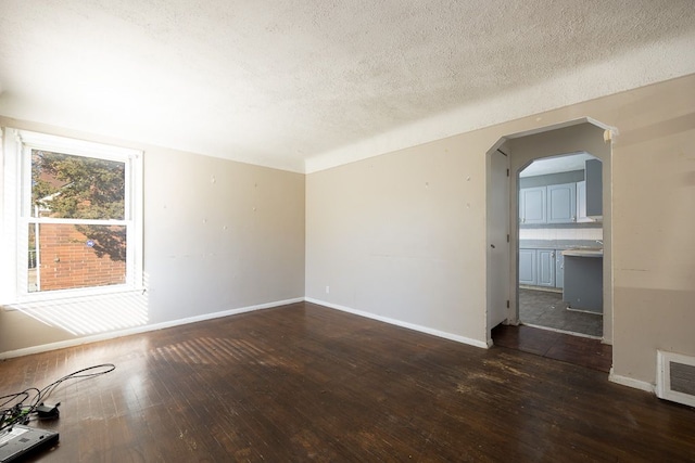 unfurnished room featuring a textured ceiling and dark wood-type flooring