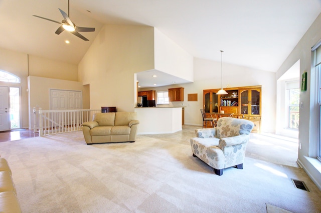 carpeted living room featuring ceiling fan and high vaulted ceiling