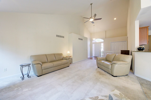 carpeted living room with ceiling fan and high vaulted ceiling