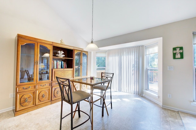 dining area featuring high vaulted ceiling