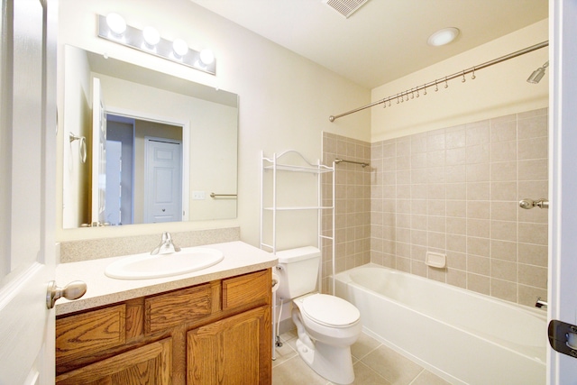 full bathroom featuring tile patterned flooring, vanity, tiled shower / bath combo, and toilet