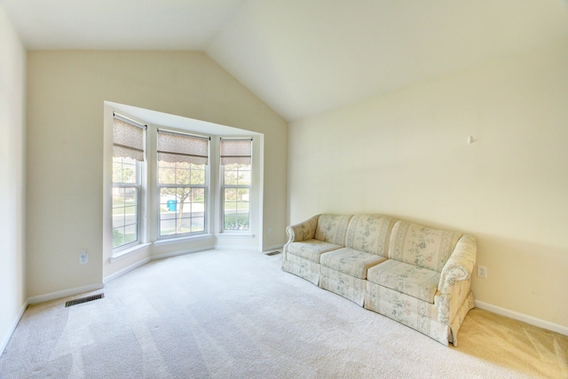 living room featuring light carpet and vaulted ceiling