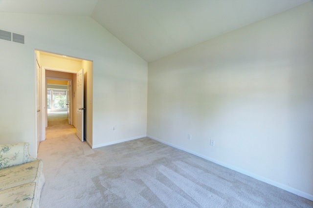 carpeted empty room featuring vaulted ceiling