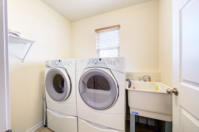 clothes washing area with washing machine and dryer and sink