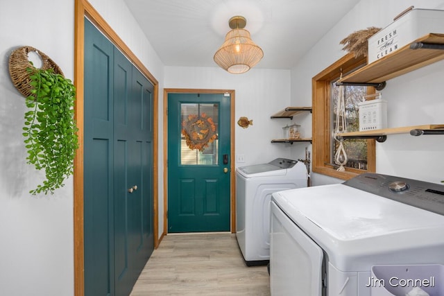 laundry area featuring light hardwood / wood-style floors and washing machine and clothes dryer