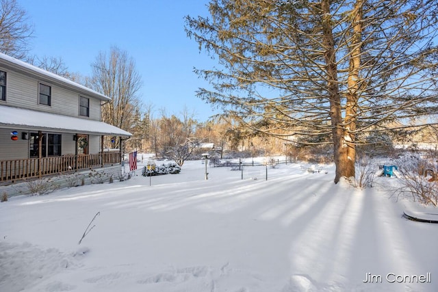 yard covered in snow featuring covered porch