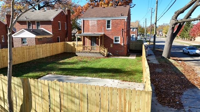 rear view of property featuring a lawn